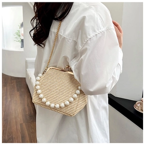 Vue détaillée d'un sac à bandoulière en paille tressée beige orné de grandes perles blanches