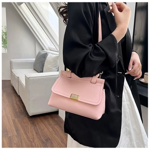 Detail of soft pink lychee pattern leather handbag with elegant gold metal buckle hardware