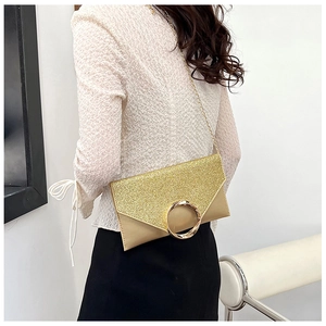 Detailed view of a gold sequin envelope clutch featuring a large metal ring and chain strap