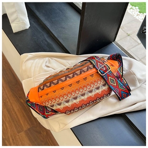 Detail of colorful geometric woven pattern and wide jacquard strap on orange ethnic fanny pack