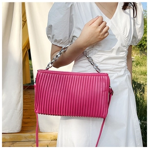 Detail of fuchsia pleated shoulder bag with silver metal chain strap and long leather strap