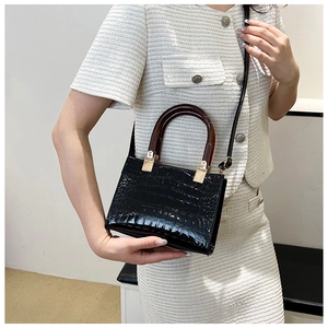 Detail of black stone texture handbag with tortoiseshell handle and gold hardware