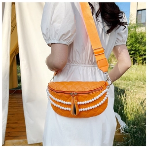 Détail du sac ceinture matelassé orange vif avec chaîne en perles et bandoulière large