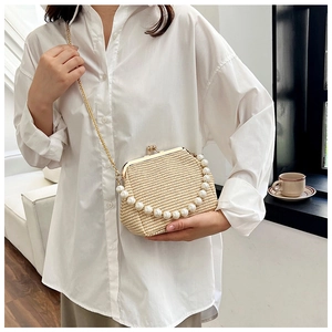 Détail du sac à bandoulière en paille tissée avec poignée en perles et fermoir métallique