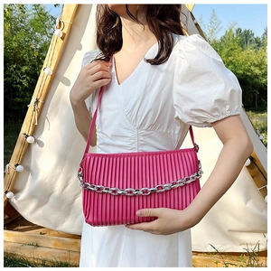 Detail of hot pink pleated shoulder bag featuring a bold silver chain and soft texture