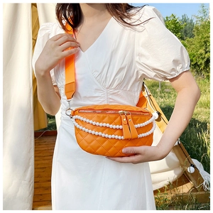 Détail du sac banane orange matelassé avec chaîne de perles et large bandoulière