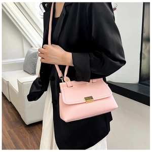 Detailed macro view of pink lychee pattern leather and gold metal buckle on handbag