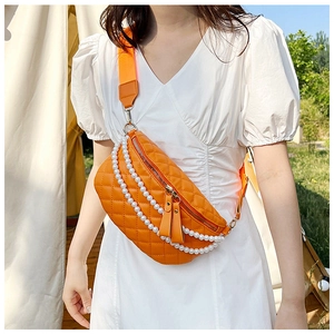 Détail du sac de poitrine orange matelassé avec chaînes de perles et large bandoulière