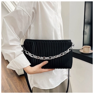 Detail of black pleated bag featuring silver chunky chain and adjustable shoulder strap