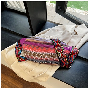 Close-up of ethnic embroidered waist bag featuring wave texture and colorful woven strap