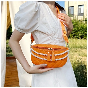 Détail du sac de poitrine orange matelassé avec chaîne en perles et bandoulière large