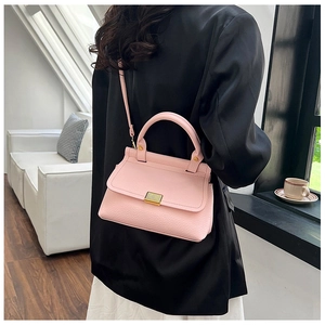 Pink lychee texture crossbody bag styled with a black blazer for an elegant look
