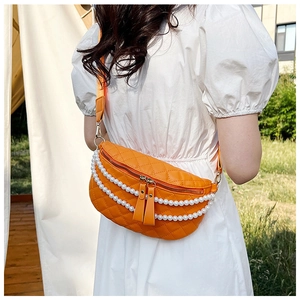 Détail du sac bandoulière orange matelassé avec chaînes de perles et bandoulière