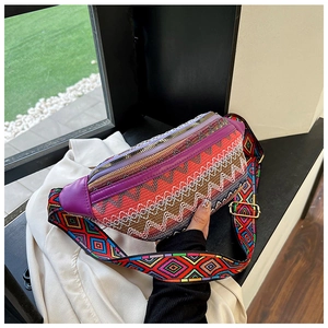 Detail of ethnic embroidered waist bag featuring colorful geometric patterns and wide strap