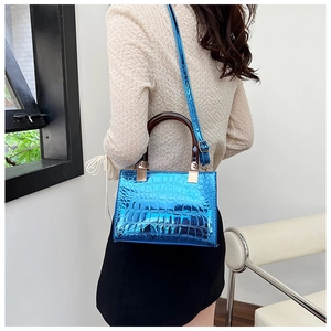 Blue glossy crocodile pattern handbag with tortoiseshell handle shown on a model