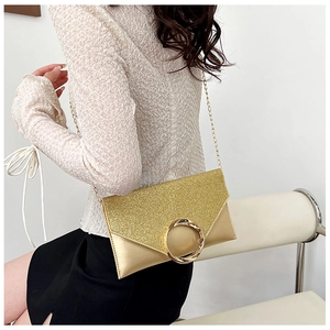 Detail of elegant gold envelope clutch with sequin texture and round metal buckle
