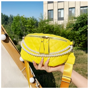 Détail du sac banane matelassé jaune avec chaîne en perles et bandoulière large en plein air
