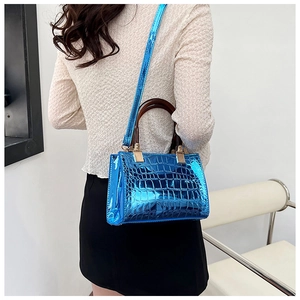 Close-up of bright blue crocodile pattern tote bag with vintage brown wooden handle