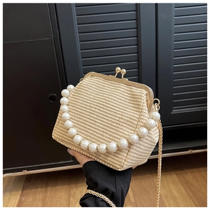 Détail du sac coquillage en paille avec poignée en perles et bandoulière chaîne dorée