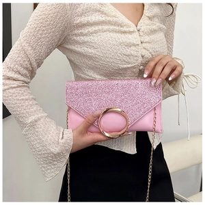 Detailed macro view of pink sequin envelope clutch featuring a gold round buckle closure