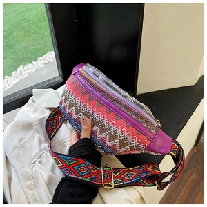 Close-up of bohemian embroidered waist bag with colorful geometric patterns and gold zipper