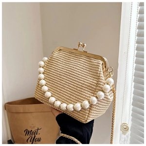 Détail du sac coquillage tissé beige avec poignée en perles et fermoir en métal doré