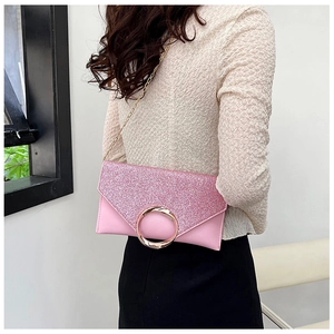 Close-up of pink sequined envelope bag with gold ring buckle and metal chain strap