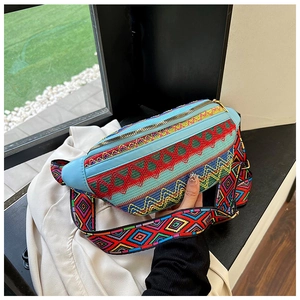 Detail of bohemian embroidery waist bag with sky blue leather trim and golden zipper