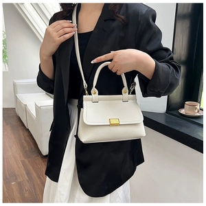 Chic cream litchi texture handbag styled on a model in a bright modern interior
