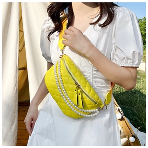 Détail d'un sac banane jaune matelassé avec chaînes de perles sur un mannequin