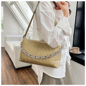 Detail of golden pleated shoulder bag with metallic PU texture and silver chain strap