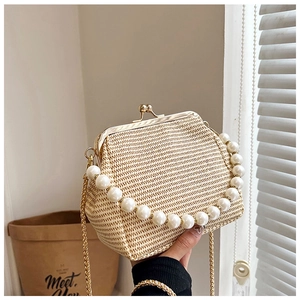 Détail du sac en paille tressée avec poignée en perles et fermoir en métal doré