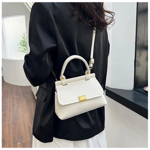 Close-up of white lychee textured shoulder bag with golden metal buckle and leather handle