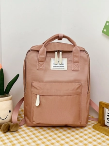 Detailed close-up of a sweet pink college-style backpack featuring a front zipper pocket