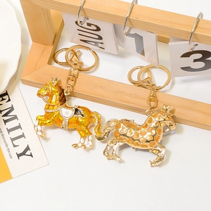 Portachiavi a forma di cavallo in smalto dorato e arancione con cristalli su scrivania