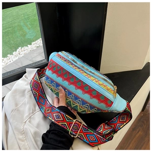 Detail of ethnic embroidered waist bag with colorful diamond pattern and blue leather accents
