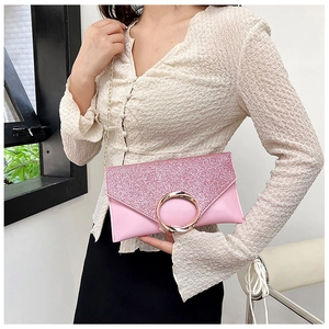 Detailed macro view of pink sequin evening bag with gold circular metal buckle closure