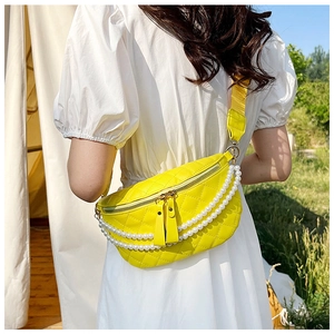 Détail du sac banane matelassé jaune avec chaînes de perles blanches et large bandoulière