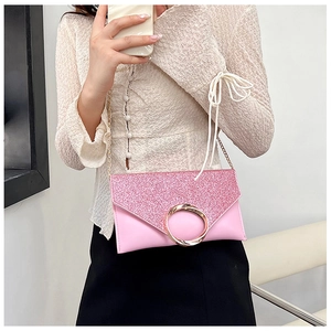 Detailed view of pink sequin envelope bag with golden metal chain and round buckle