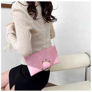 Pink envelope evening bag with glitter flap and gold ring buckle worn by a model