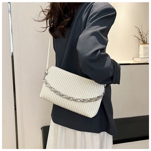 White ruched shoulder bag with silver chain detail shown on model in modern office outfit
