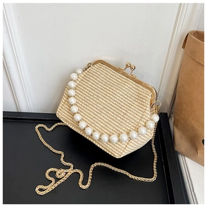 Détail d'un sac tressé style paille avec poignée en perles et fermoir en métal doré