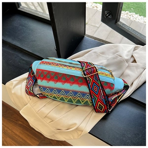 Detail of colorful ethnic embroidery with geometric patterns and woven strap on waist bag