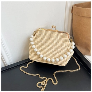 Détail du sac coquillage en paille tressée avec anse en perles et fermoir doré