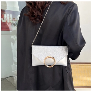 Silver envelope clutch featuring sparkling sequins, smooth leather, and a gold metal ring
