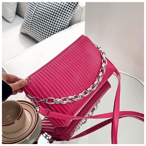 Detail of fuchsia pleated shoulder bag with chunky silver chain and glossy PU leather finish