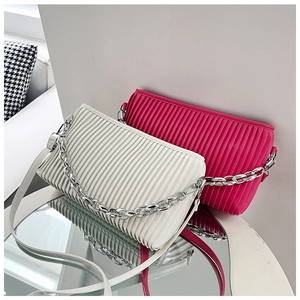 Detailed view of pleated shoulder bags in pearl white and rose red with silver chain