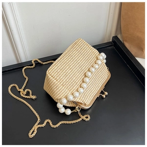 Détail du sac coquillage en paille avec poignée perle et bandoulière dorée