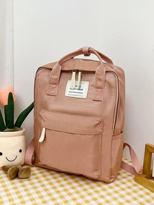 Top view of pink leisure college backpack with zipper pocket on checkered tablecloth
