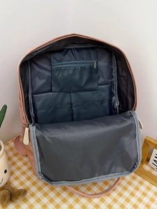 Detailed interior view of pink backpack with multi-pocket organization and grey lining